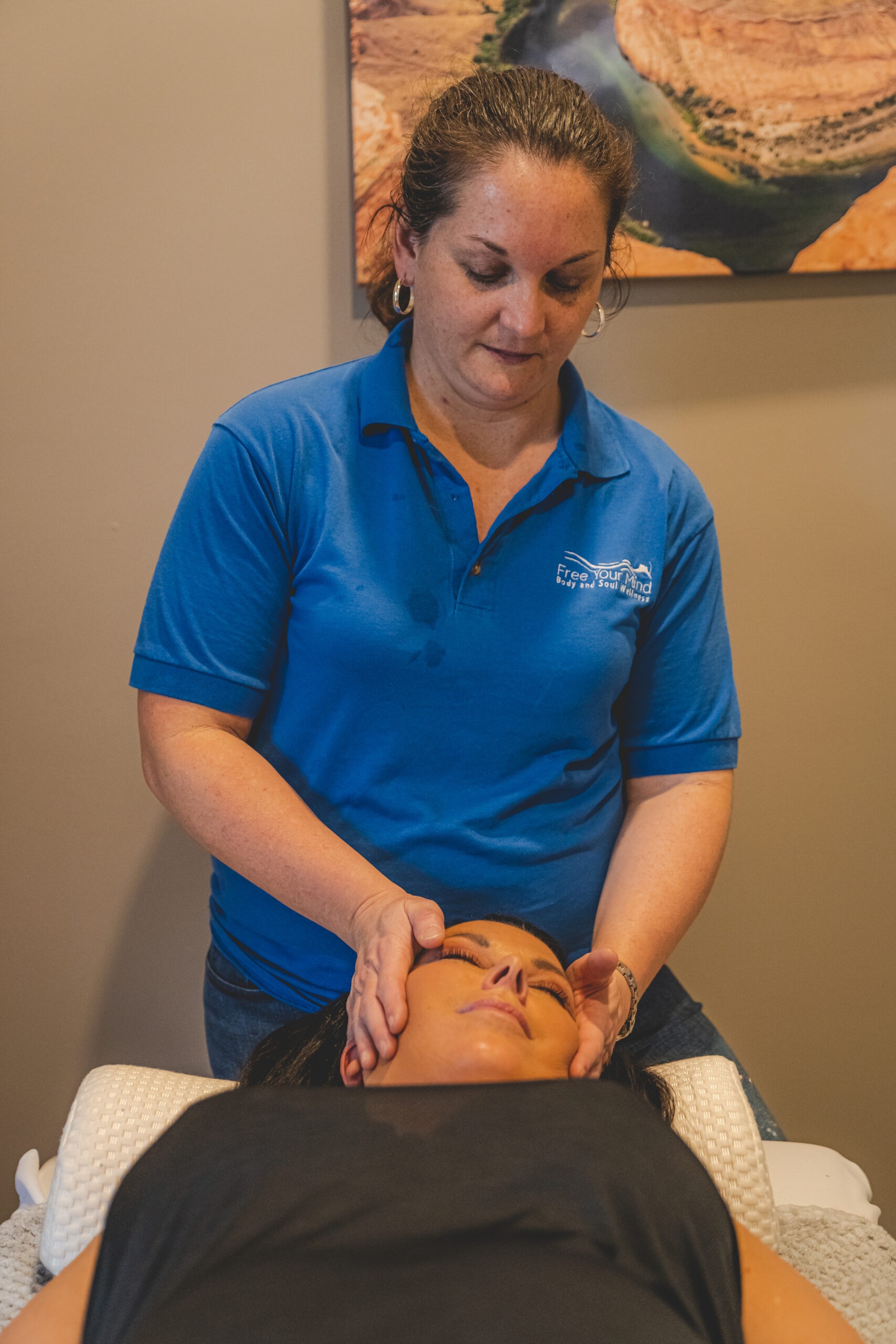 A therapist performs a facial massage on a client lying on a treatment table in a serene spa setting, promoting relaxation and rejuvenation.